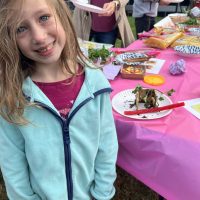 smiling kid with an edible sukkah